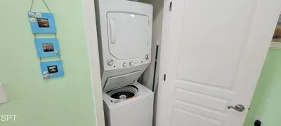 Convenient in-unit laundry with stacked washer and dryer tucked neatly in a closet. Efficient design, clean space, and easy access make it simple for guests to refresh clothes during extended stays or family vacations.