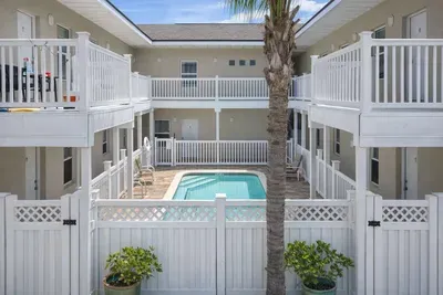 Relax by the Pool at Los Cabos – Cozy Courtyard Suites, Steps from the Beach, Private Balconies, Palm-Studded Views, and Onsite Parking at 105 E. Tarpon