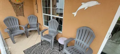 Sunny Shared Balcony with Adirondack Seating, Coastal Views & Easy Access to Each Unit — Relaxed Outdoor Space Perfect for Morning Coffee or Evening Breezes.