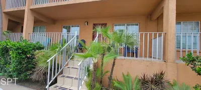 Sunny Upper Walkway with Cozy Seating, Coastal Scenery & Convenient Access to Each Unit — Great for Unwinding Outdoors.