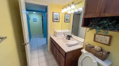 This bright bathroom features a spacious vanity with ample counter space, large mirror, and stylish lighting. Stocked with fresh towels and beachy décor, it’s a cheerful and functional space to refresh after a day in the sun.