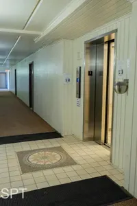Bright interior hallway with tiled floors, clean lines, and a well‑maintained elevator—offering guests smooth, convenient access throughout the property in a secure, welcoming space designed for comfort, ease, and effortless navigation.