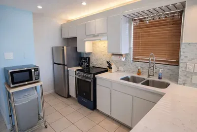 Modern Kitchen with Stainless Steel Appliances, Dual Sink, Coffee Station & Microwave Cart – Bright, Clean, and Fully Equipped for Your Stay