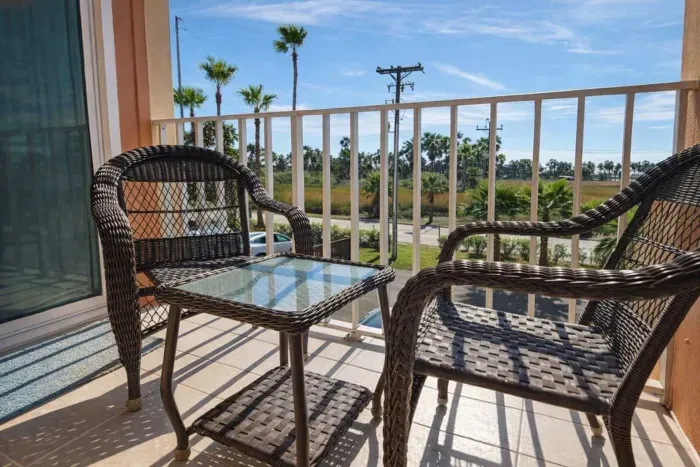 Sunny Balcony Retreat with Palm Views – Relaxing Wicker Seating & Glass Table, Steps from Coastal Vibes