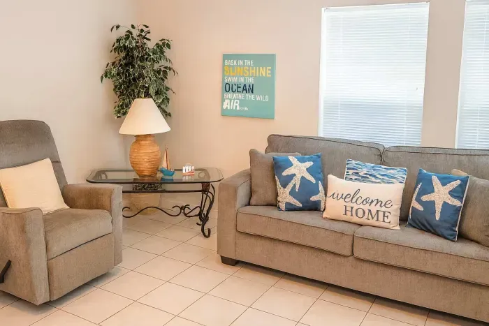 Relax in a welcoming living space with plush seating, cozy throw pillows, and cheerful coastal decor. The inviting lounge is perfect for kicking back after a day at the beach or enjoying family time in comfort and style.
