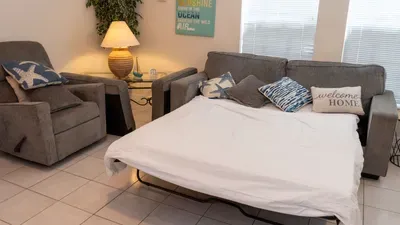 Accommodate extra guests easily with a comfy sleeper sofa in the coastal living room. Enjoy the convenience of flexible sleeping arrangements in a welcoming space, perfect for families or friends on a relaxing beach getaway.