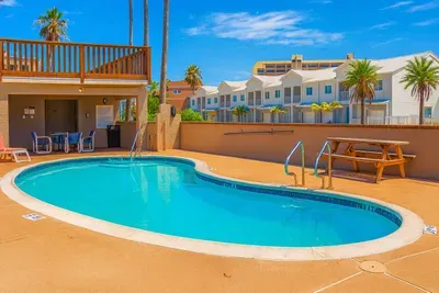 Poolside Oasis with Sun Deck
Unwind at this sunny courtyard pool with loungers, outdoor shower, picnic table, and covered lounge area. Steps from palm-lined walkways and nearby condos, it is ideal for family swims and relaxed afternoon breaks.