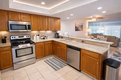 Warm, inviting kitchen flows into a bright living space—perfect for relaxed mornings or shared meals. Clean lines, natural light, and coastal charm create a welcoming feel that guests instantly connect with.
