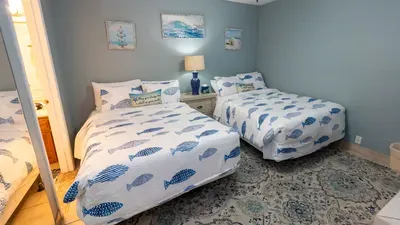 Calm, coastal twin‑bed room designed for easy relaxation, with soft tones, simple décor, and a welcoming vibe that feels naturally comforting. A bright, balanced space that brings a touch of seaside charm without leaning on amenities.