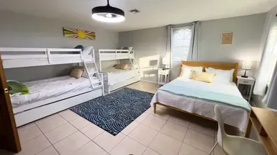 Perfect for groups or families, this bright bedroom features two bunk beds and a luxe bed, with fun décor and plenty of space. Natural light streams in, creating a cheerful vibe for a restful night's sleep or relaxing mornings together.
