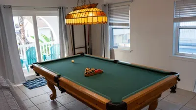 Challenge friends and family with a game of pool in the stylish rec room. Sunlight pours in, and classic decor creates a fun retreat for friendly competition. Steps from the balcony, this space is perfect for indoor entertainment and relaxation.