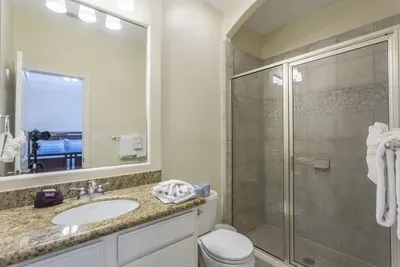 Modern Bathroom with Granite Vanity, Glass‑Door Shower & Fresh Towels — Clean, Bright & Comfortably Designed for a Relaxing Stay