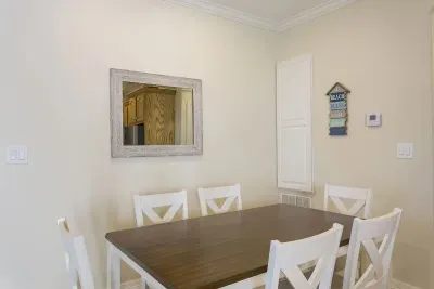 Bright Dining Space with Wooden Table, Cross‑Back Chairs & Warm Neutral Décor — Perfect for Shared Meals and Relaxed Gatherings
