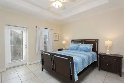Bright Bedroom with Cozy Bed, Blue‑Striped Bedding, Matching Lamps & Private Patio Access — Relaxed, Airy & Perfect for Restful Nights