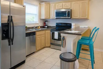 Modern Kitchen with Stainless Steel Appliances, Granite Counters, and Bright Breakfast Bar—Perfect for Cooking & Entertaining
