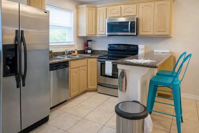 Modern Kitchen with Stainless Steel Appliances, Granite Counters, and Bright Breakfast Bar—Perfect for Cooking & Entertaining