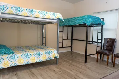 Bright, efficient bunk‑bed room designed for groups, featuring mixed metal frames, cozy seating, soft natural light, and clean finishes. A practical, budget‑friendly setup ideal for families, teams, or friends seeking comfort and convenience.