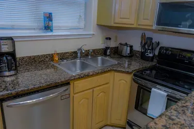 Clean, well‑organized kitchen featuring stainless appliances, granite counters, light wood cabinetry, and everyday essentials like a coffee maker and toaster. A practical guest‑ready space designed for easy meal prep, convenience, a comfortable stay.