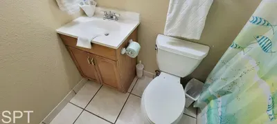 A clean, thoughtfully prepared bathroom with a bright vanity, crisp towels, and a tidy shower area, offering guests a refreshing, comfortable place to unwind, complete with neatly arranged essentials for a smooth stay.