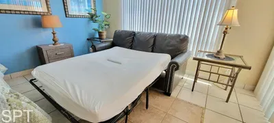 A versatile living space featuring a pull‑out sofa bed, warm lighting, and thoughtful décor, offering guests a comfortable, flexible area to sleep, relax, and unwind with convenient bedside lighting and a bright, welcoming layout throughout.