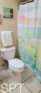 A bright, well-kept bathroom featuring a spotless vanity, fresh towels, and a clean shower area, offering guests a tidy, comfortable space to refresh and unwind during their stay, with essentials thoughtfully provided throughout.