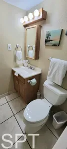 A tidy, inviting bathroom featuring a polished vanity, soft towels, and a clean shower area, creating a simple, comfortable space for guests to refresh and reset, with all the essentials neatly arranged for convenience.
