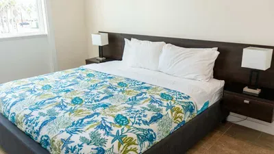 Spacious bedroom with a comfortable bed, fresh linens, and modern décor. Large windows let in natural light and offer neighborhood views. A quiet retreat designed for rest and relaxation after a fun-filled day on South Padre Island.