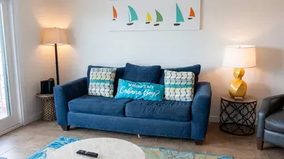Bright and cheerful living nook with a plush navy sofa, colorful pillows, and warm lighting. Perfect for relaxing with a book, sipping coffee, or enjoying a cozy evening after exploring South Padre Island. Stylish, comfy, and inviting.