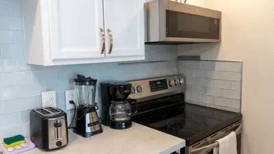 Modern kitchen with stainless steel appliances, coffee maker, blender, toaster, and microwave. Fully equipped for cooking and convenience, perfect for enjoying meals during your South Padre Island stay at La Internacional.