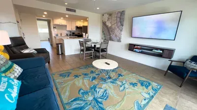 Bright and inviting living space with modern décor, flat-screen TV, cozy sofa, and dining area. Open layout flows into the kitchen, creating the perfect spot to relax, enjoy meals, or spend time together during your South Padre Island stay.
