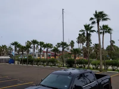 Coastal arrival spot framed by tall palms, vibrant local buildings, and a relaxed beach‑town vibe. A convenient, welcoming area that sets the tone for easy access, laid‑back stays, and the colorful charm of a tropical destination.