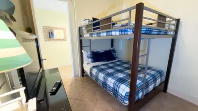 Cozy bunk‑room setup with a simple, relaxed feel—clean lines, soft tones, and an easy layout that makes settling in feel natural. A grounded, welcoming space that fits effortlessly into a beachside stay.