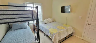 Enjoy versatile comfort in this cozy bedroom featuring a serene bed, bunk beds, natural light, and modern amenities—perfect for families, couples, or groups seeking relaxation, convenience, and memorable coastal stays.