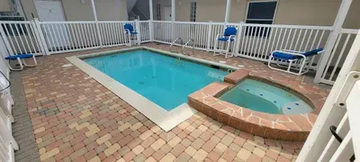 Relax in style at this inviting poolside escape, featuring a sparkling pool, soothing tub, and comfortable lounge seating—perfect for families, couples, or groups seeking leisure, comfort, and memorable coastal stays.