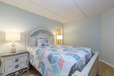 Settle into this inviting bedroom with its elegant wooden frame, cozy layered linens, balanced lighting, and thoughtful décor—offering a calm, comfortable space designed for restful nights and relaxed mornings during your coastal stay.