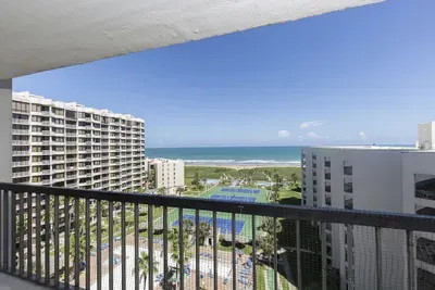 Enjoy sweeping Gulf views from this high‑floor balcony overlooking resort pools, tennis courts, and pristine shoreline—an inviting spot for sunrise coffee, breezy afternoons, and unwinding above the vibrant coastal scene.