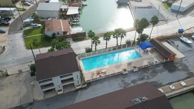 Enjoy a serene waterfront escape with a sparkling pool, palm‑lined deck, and relaxing lounge spaces overlooking the marina. Perfect for sunny afternoons, peaceful mornings, and effortless coastal living just steps from your stay.