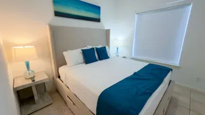 Serene Bedroom Suite
Plush comfy bed draped in blue hues glows under soft lamps in this tranquil master retreat. Ocean art and light-filtering blinds create peaceful vibes—wake refreshed for beach adventures ahead!