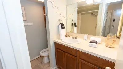 A softly lit vanity space with clean lines and warm tones, creating an easy, relaxed feel that fits naturally into an unhurried beach‑day rhythm. The simple layout and calm palette make the room feel welcoming without trying too hard.