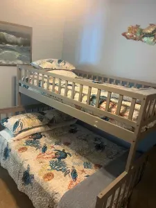A cozy, compact bedroom with a simple bunk setup and soft coastal touches that keep the space feeling relaxed and welcoming. The calm colors and easy layout create a comfortable spot to settle in, offering a warm, unhurried vibe throughout the stay.