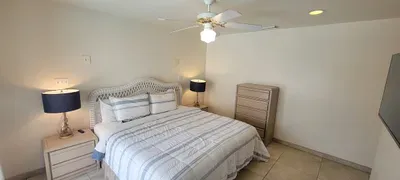 Bright, airy bedroom with a cozy bed, soft coastal tones, matching lamps and simple modern décor. A relaxing retreat designed for restful nights and a calm, comfortable stay.