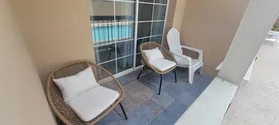 Cozy patio nook with wicker seating, tiled flooring, and easy access to the pool area. A relaxing spot for morning coffee, quiet conversations, or unwinding between swims.