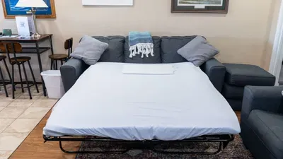 A bright, functional living area with a plush sofa bed, cozy seating, and a vibrant rug that brings the room to life. Great for additional guests, this space blends comfort and convenience for easy lounging and restful nights.