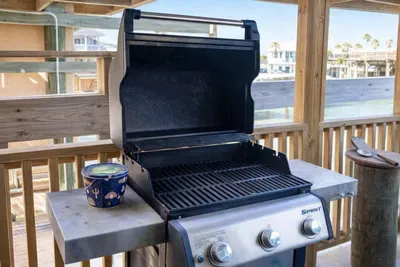 Covered patio with clean gas grill, perfect for outdoor cooking and entertaining. Ideal for beachside BBQs, family meals, or sunset grilling with a view.