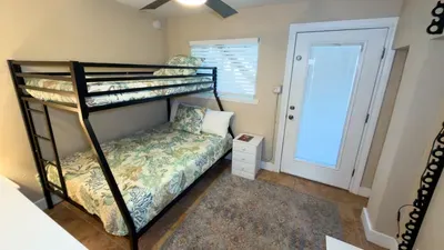 This bright, efficient bedroom features a twin‑over‑full bunk setup with fresh linens, warm natural light, and simple, functional décor. A great space for families or groups, offering comfort, practicality, and a clean, welcoming place to unwind.