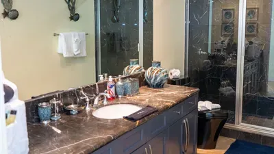 A modern bathroom with dark finishes, clean lines, a calm, uncluttered layout that keeps the space feeling grounded & welcoming. Soft tones and simple details create an easy, relaxed atmosphere that makes freshening up feel unhurried and comfortable.