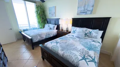 A bright, coastal bedroom with twin beds, soft natural light, and a clean, easy layout that feels relaxed and welcoming. The calm colors and simple styling create an inviting atmosphere that makes settling in feel effortless from the start.