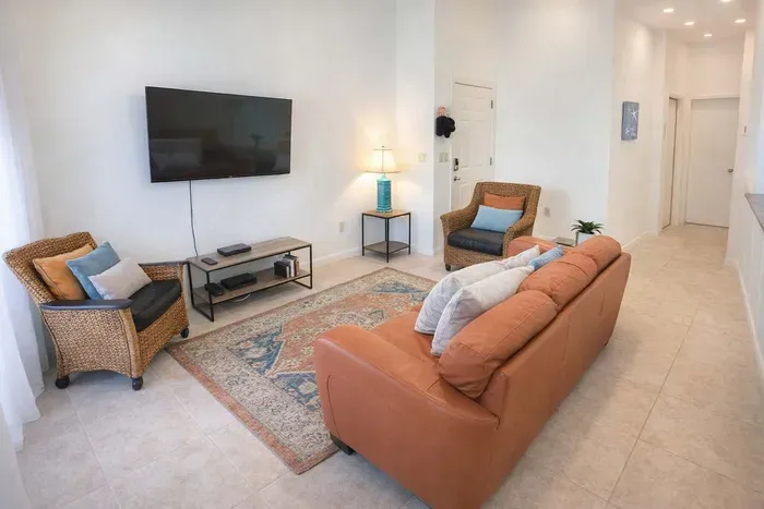 Cozy Beach-Inspired Living Room | Bright, Inviting Space with Smart TV, Wicker Seating & Coastal Decor | Perfect for Relaxing After a Day at the Shore