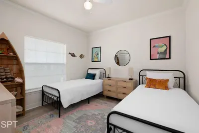 A softly styled room with twin beds, warm natural textures, and simple décor that feels calm and easy to settle into. Thoughtful touches, gentle light, and a clean layout create a space that feels welcoming for friends, families, or relaxed getaways.