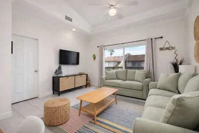 Bright Coastal Retreat w/ Balcony, Palm Views & Stylish Decor – Walk to Beach, Dining & Shops